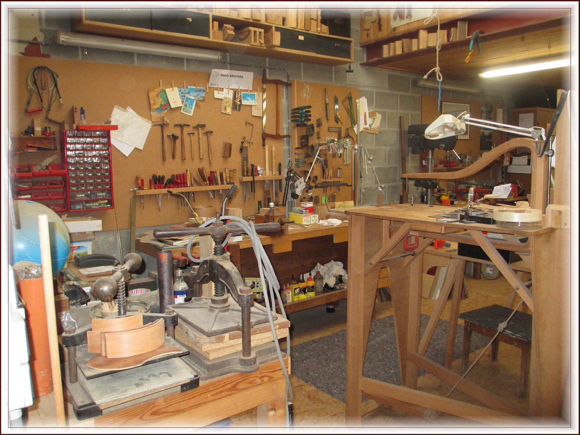 Atelier d’ébéniste : presse, établi et mur d’outils